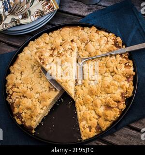 Round crumble pie on a blue napkin on a wooden table Stock Photo
