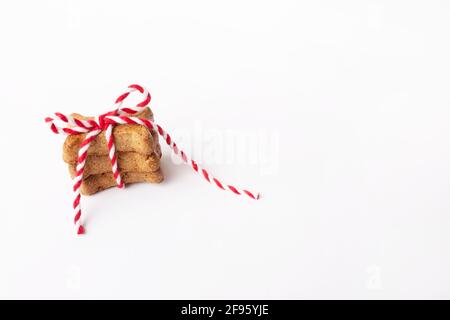 Small stack of three brown dog biscuits tied in red and white string Stock Photo
