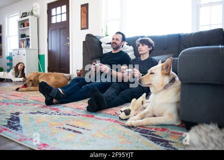 Father and tween son playing video games together. Stock Photo