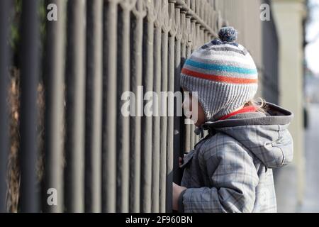 The child looking through the iron grating Stock Photo