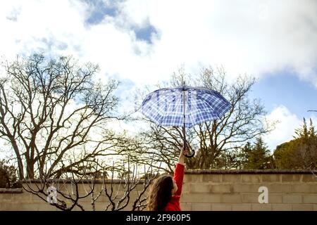 woman's arm holding an umbrella against cloudy sky Stock Photo