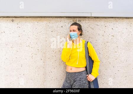 Active woman with sportswear and mat talking on the phone Stock Photo