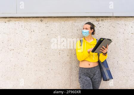 Active woman with tablet sportswear and mask using tablet Stock Photo