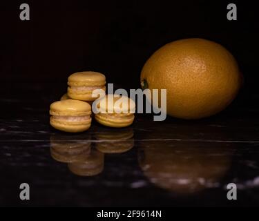 Mini Lemon Macarons on Black Marble Stock Photo