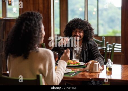 Couple sitting at the table happily enjoying their food Stock Photo