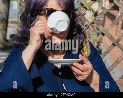 Senior adult woman drinking cappuccino Stock Photo