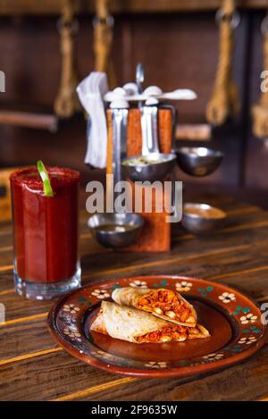 Mexican burrito and michelada beer with tomato juice with copy space. Stock Photo