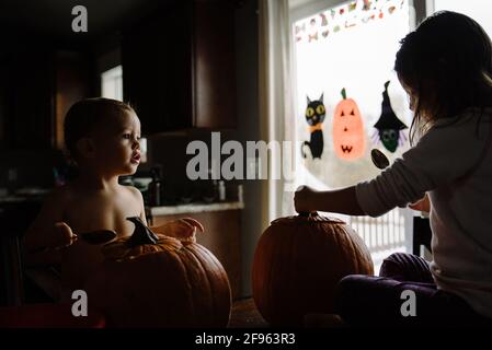 two kids Pumpkin carving at halloween in their home Stock Photo