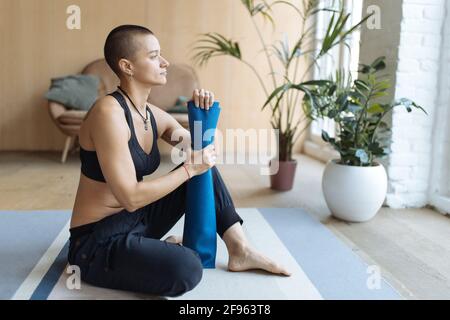 athletic woman with yoga mat looking at window Stock Photo