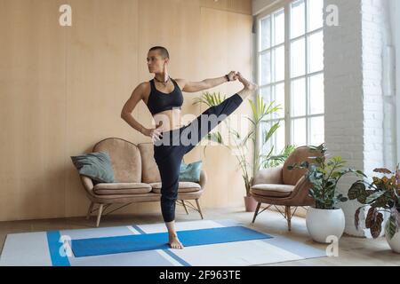 fit female doing yoga balance exercise at home Stock Photo