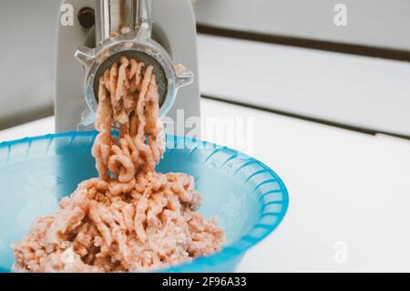 Minced meat is being prepared in the kitchen. Meat grinder close up Stock Photo