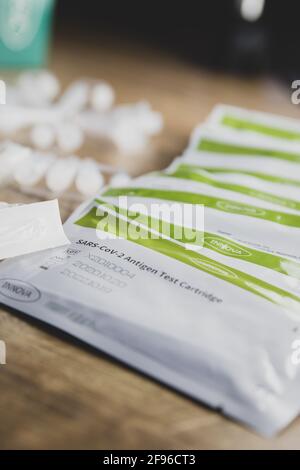 Home testing kit for school children and NHS staff, also called Lateral Flow tests for Covid 19, for testing at home. Covid immunisation cards. Stock Photo