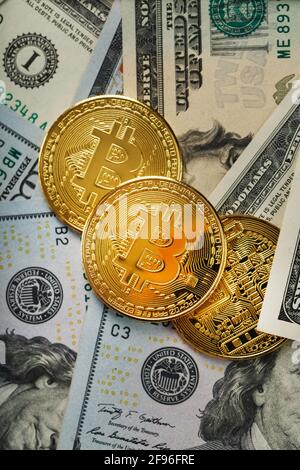 Bitcoin gold coins on US dollar bills. The concept of a peer-to-peer payment system that uses the same unit for accounting transactions. Stock Photo