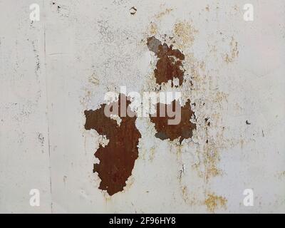Corroded metal background. Rusted white painted metal wall. Rusty metal background with streaks of rust. Rust stains. The metal surface rusted spots. Stock Photo