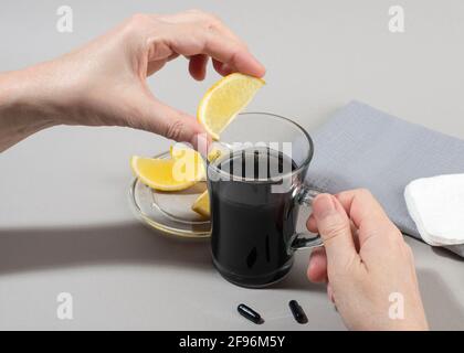 Womans hands making detox drink with activated charcoal. Close up. Healthy lifestyle concept. Stock Photo