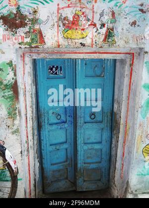 A decorative blue door gate of local residence in narrow alley between colourful houses in Varanasi, India. The old city of Varanasi is a network of n Stock Photo