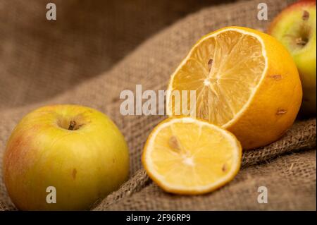 Sliced lemon and fresh green apples on a homespun cloth with a rough texture. Close-up selective focus. Stock Photo