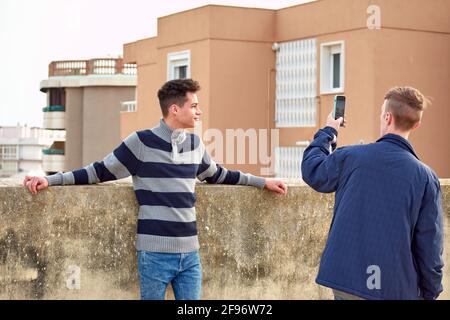Young male taking photos of his friend outdoors Stock Photo