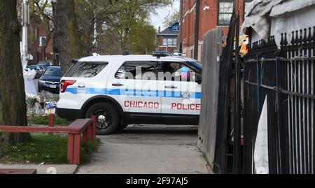 Chicago, Illinois, USA. 16th Apr, 2021. Memorials are seen at W. 24th St. and S. Sawyer Ave. in Chicago, Illinois, where 13-year-old Adam Toledo was shot and killed early March 29 by a Chicago police officer who was chasing him down the alley Friday April 16, 2021. A Chicago patrol car drives past memorials and into the alley Body camera video released April 15 shows that Toledo had apparently tossed the gun he was holding inside the wood stockade fence in the alley. He had his hands up in a gesture of surrender when he was shot. (Credit Image: © Mark HertzbergZUMA Wire) Stock Photo