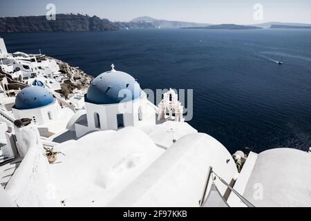 Scenic view of Oia on Santorini island with traditional cycladic, white houses and churches with blue domes over the Caldera, Aegean sea, Greece, Stock Photo