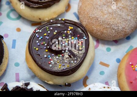 A delicious selection of colourful doughnuts including a chocolate one with sprinkles Stock Photo
