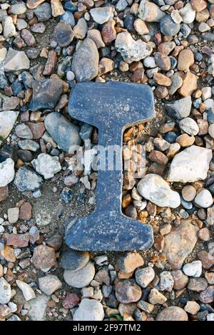 A section of bullhead railway track protruding from the beach at Whitstable, Kent, UK. Stock Photo