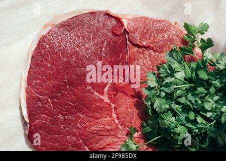 raw beef with parsley on parchment Stock Photo