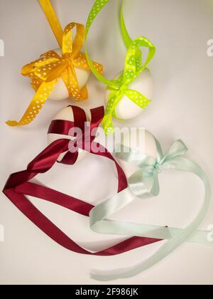 four eggs decorated with colorful ribbons with bows Stock Photo