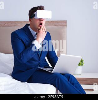 The businessman wearing a virtual reality headset in the bedroom Stock Photo