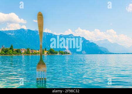 Statue of a giant fork stitched into the Geneva lake in Switzerland Stock Photo