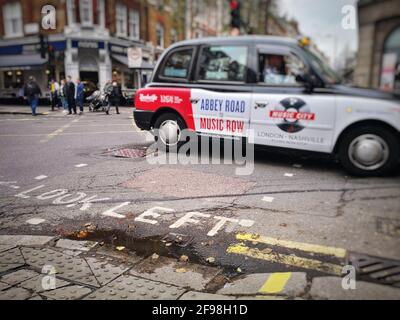 Left-hand traffic in London with a passing taxi Stock Photo