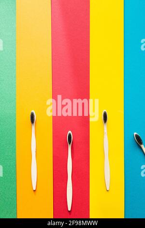 Composition of organic bamboo toothbrushes on the bright multi colored background. Natural oral hygiene. Zero waste dental protection. Stock Photo