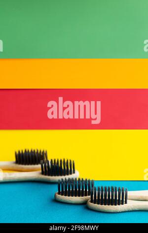 Composition of organic bamboo toothbrushes on the bright multi colored background. Natural oral hygiene. Zero waste dental protection. Stock Photo