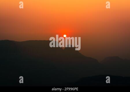 Spectacular silhouette view during sunset in Sahyadri mountain range on a winter evening from Sunset point at Matheran, Maharashtra, India. Stock Photo