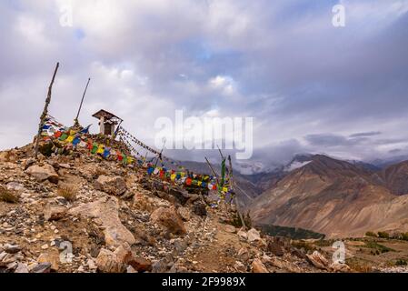 Giant Buddhist prayer wheel in Nako village in background at Spiti valley in Kinnaur district of Himachal Pradesh, India. Stock Photo