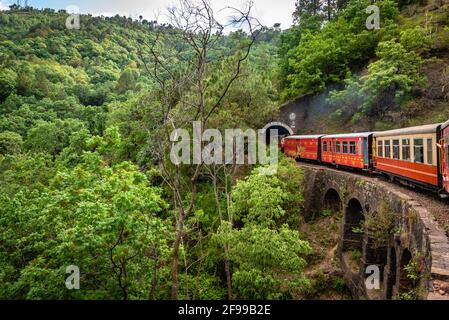 View from moving train on arch bridge over mountain slopes, beautiful view, one side mountain, one side valley. Toy train from Shimla to Kalka in Hima Stock Photo
