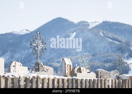 A wrought-iron metal cross in a cemetery in the Bavarian mountains. Stock Photo