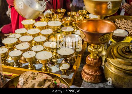 Butter diya or lamps of brass & Torma made from barley flour and butter used in tantric rituals or offerings is conspicuous feature of Tibetan Buddhis Stock Photo