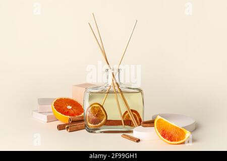 Reed diffuser with cinnamon and grapefruits on light background Stock Photo