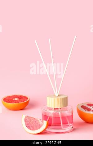 Reed diffuser with grapefruits on color background Stock Photo