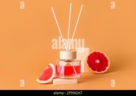 Reed diffuser with grapefruits on color background Stock Photo