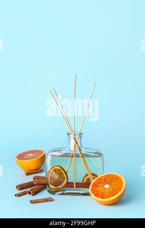 Reed diffuser with cinnamon and oranges on color background Stock Photo