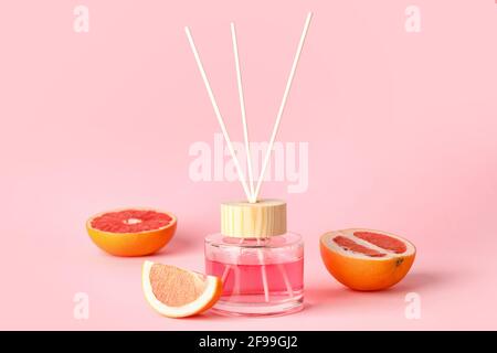 Reed diffuser with grapefruits on color background Stock Photo
