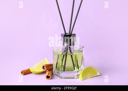 Reed diffuser with lime and cinnamon on color background Stock Photo