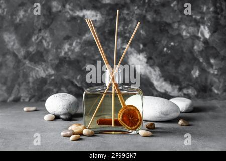 Reed diffuser with cinnamon, citrus and spa stones on grunge background Stock Photo