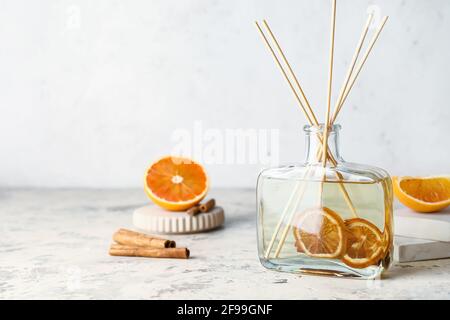 Citrus reed diffuser with cinnamon on table Stock Photo