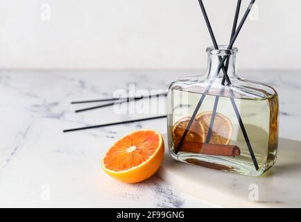 Citrus reed diffuser with cinnamon on light background Stock Photo