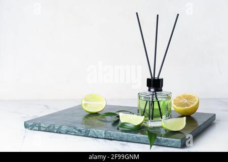 Reed diffuser with lemon and lime on light background Stock Photo