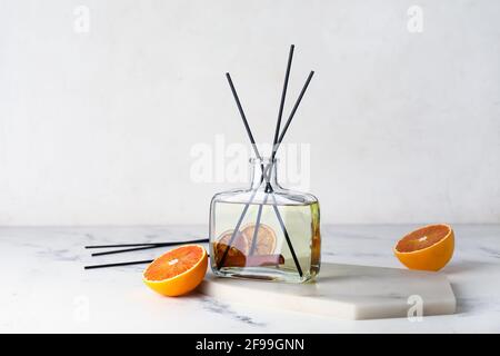 Citrus reed diffuser with cinnamon on light background Stock Photo