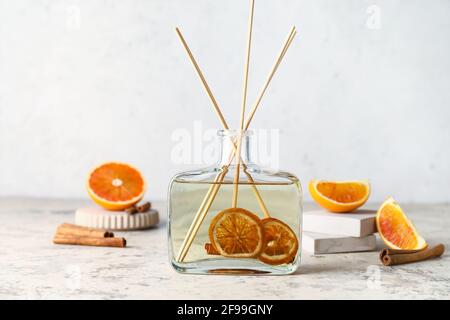 Citrus reed diffuser with cinnamon on table Stock Photo